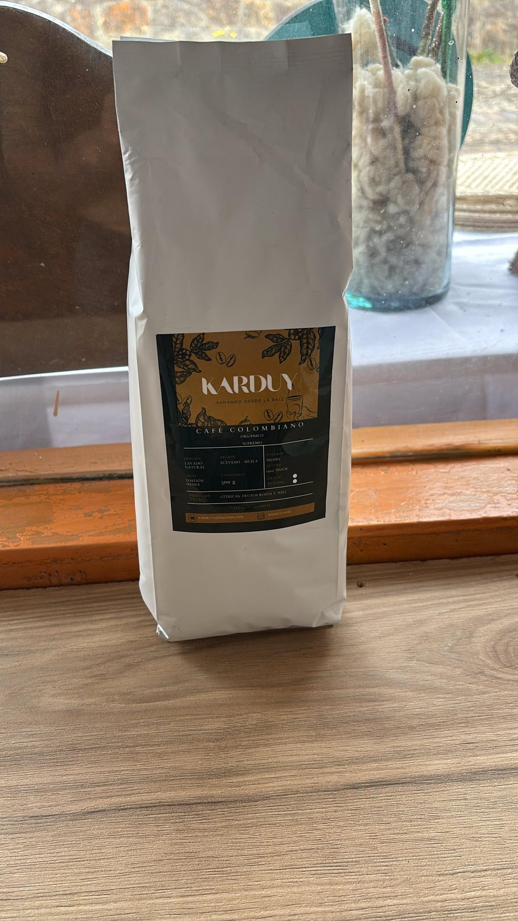 Bolsa de papel kraft de Café Colombiano Karduy sobre una mesa de madera