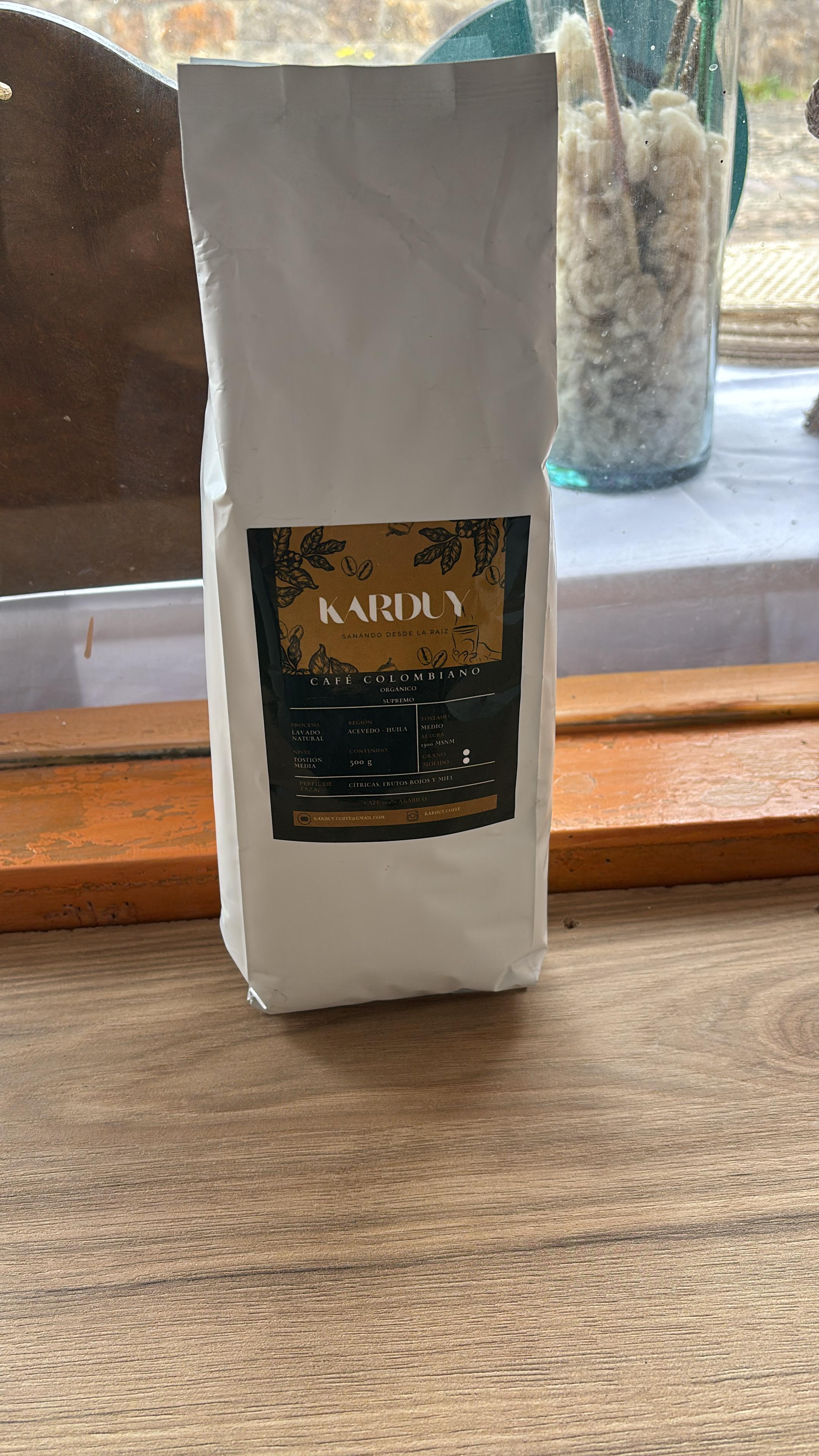 Bolsa de papel kraft de Café Colombiano Karduy sobre una mesa de madera