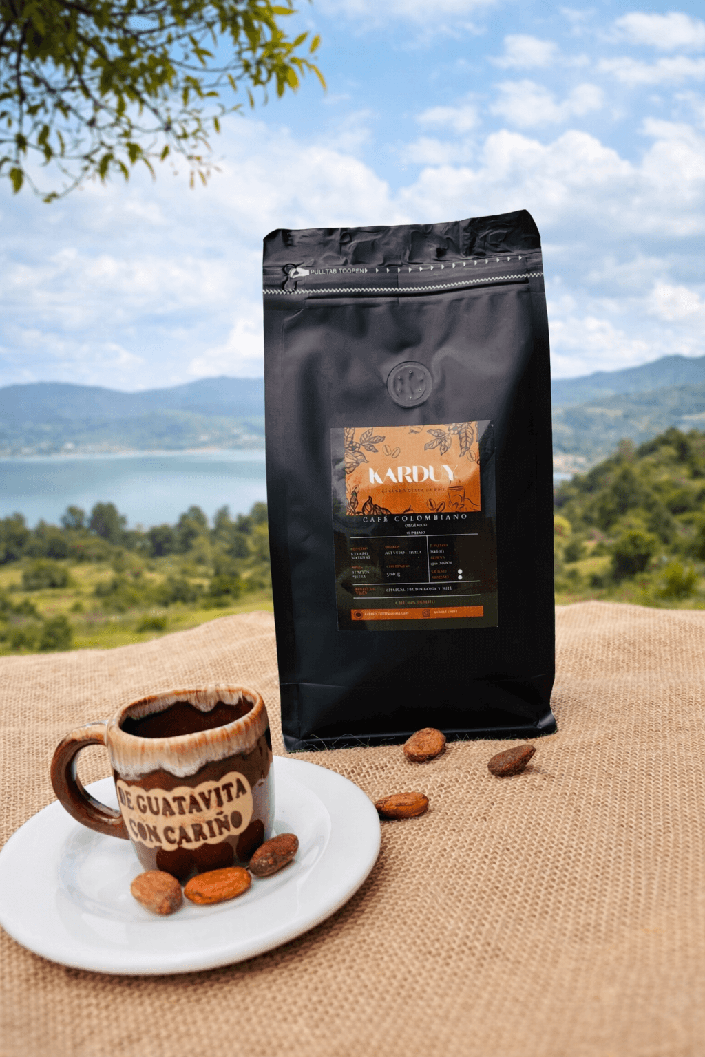 Bolsa de Café 100% Colombiano Karduy junto a una taza de café con vista al paisaje de Guatavita